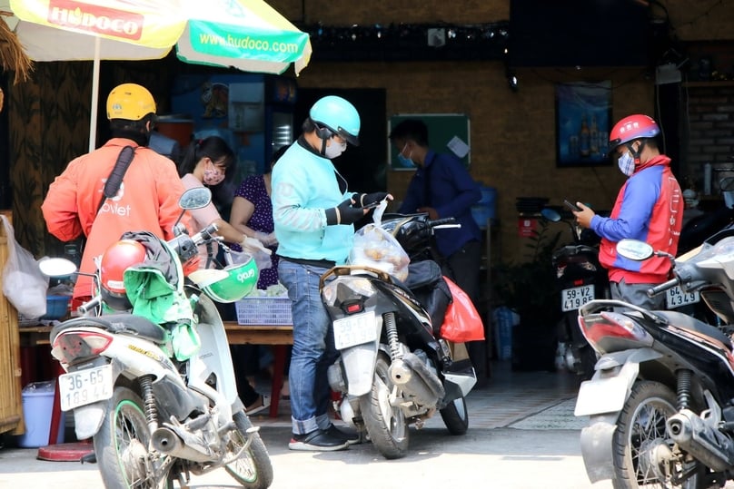 Some shippers wait for online food orders. Photo courtesy of Thanh Nien (Young People) newspaper.